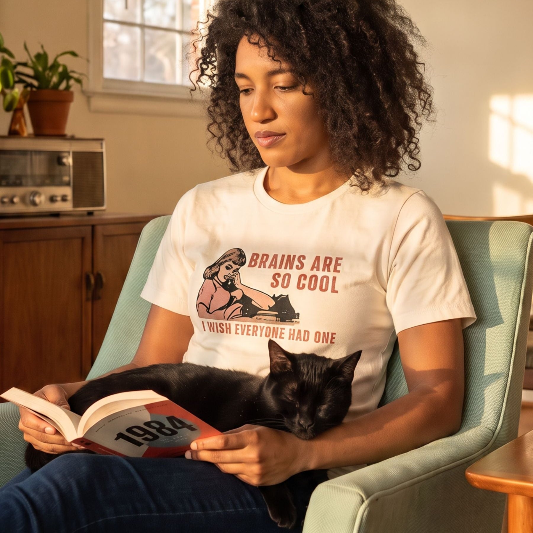 Brains Are So Cool retro-inspired graphic tee on woman reading book with black cat asleep on her lap — Galactic Ink Club
