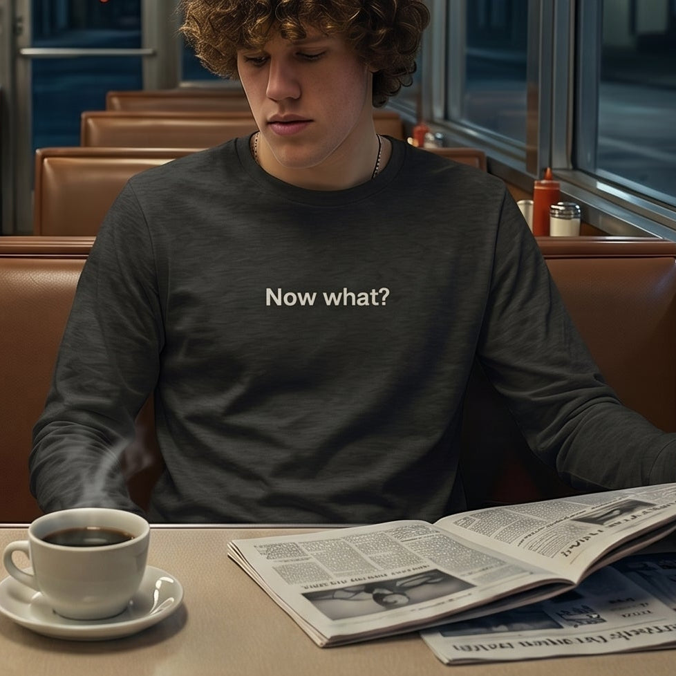Now What? retro-inspired long-sleeve graphic tee worn by young man in retro diner at night — Galactic Ink Club