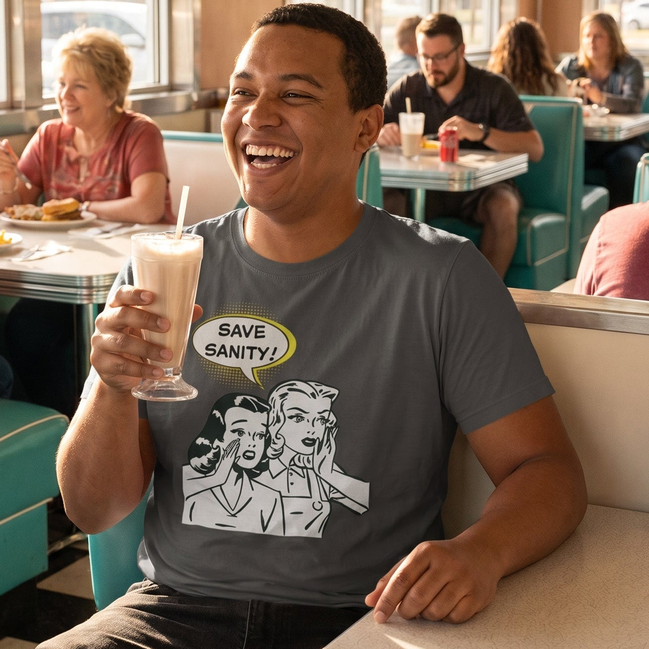 Save Sanity retro-inspired graphic tee worn by man in retro diner holding milkshake and laughing — Galactic Ink Club